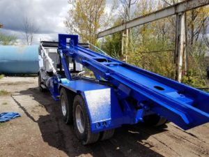 A photo showing a just painted JT Fabrication Roll Off Container Truck Body